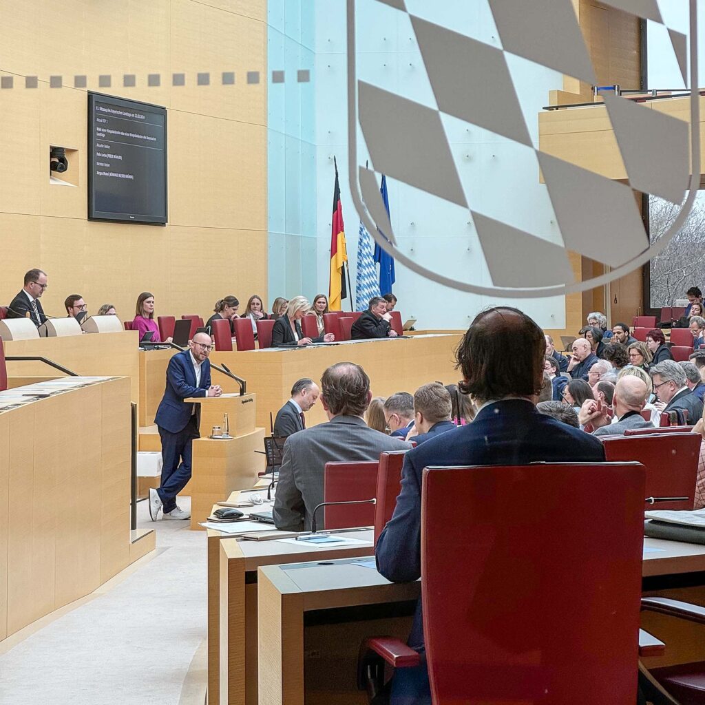 Bild von Felix Locke während er im bayerischen Landtag vor den Abgeordneten eine Rede hält